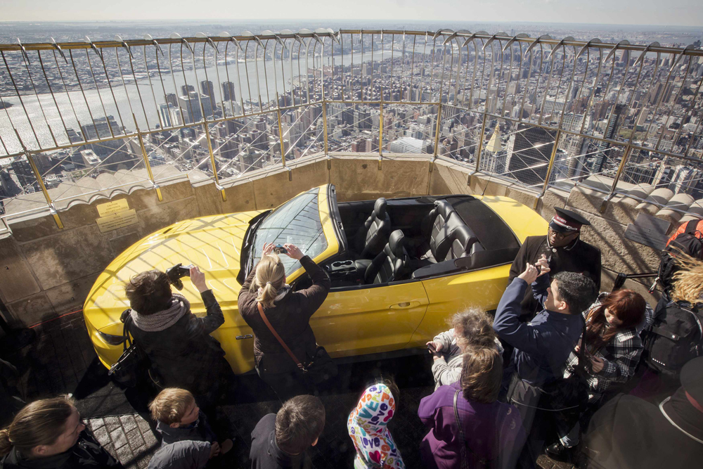 Tourists look at new 2015 Ford Mustang GT on the observation deck of Empire State Building in New York